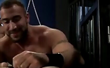 Muscular bodies in a group fetish sex scene